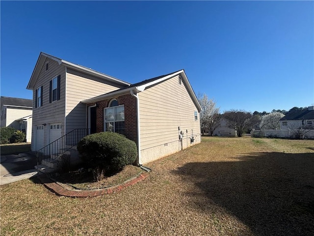 view of home's exterior featuring brick siding, driveway, a yard, crawl space, and an attached garage