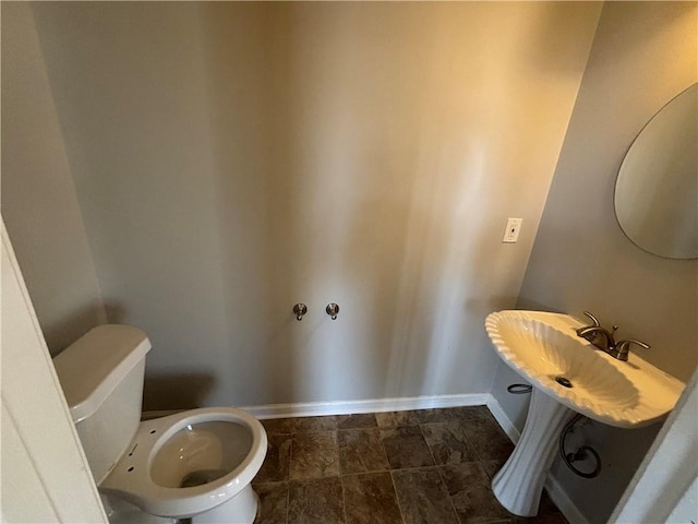 bathroom with toilet and baseboards