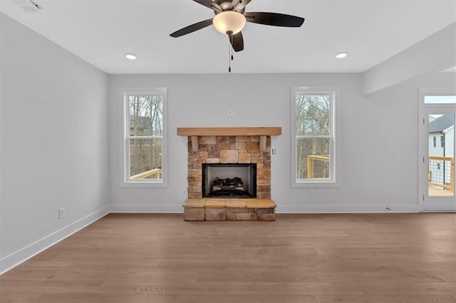 unfurnished living room featuring ceiling fan, a fireplace, and light hardwood / wood-style floors