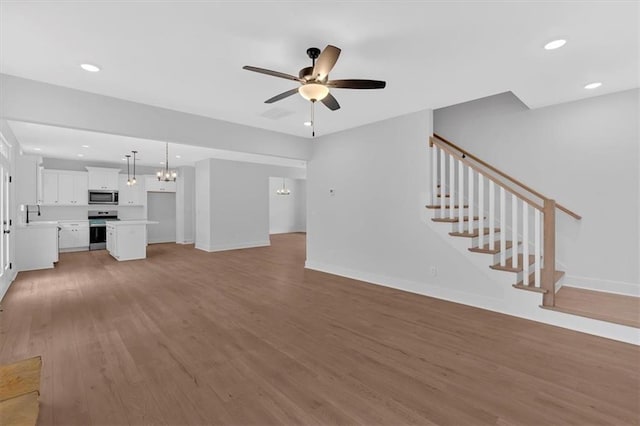 unfurnished living room featuring ceiling fan and hardwood / wood-style floors