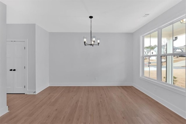 unfurnished dining area featuring light hardwood / wood-style flooring and a notable chandelier