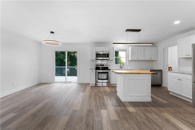 15 Baker St, Cartersville, GA 30120 - kitchen with butcher block countertops, stainless steel appliances, white cabinetry, wood finished floors, and a center island