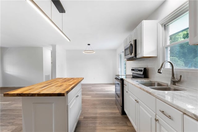15 Baker St, Cartersville, GA 30120 - kitchen featuring appliances with stainless steel finishes, butcher block counters, white cabinets, and backsplash