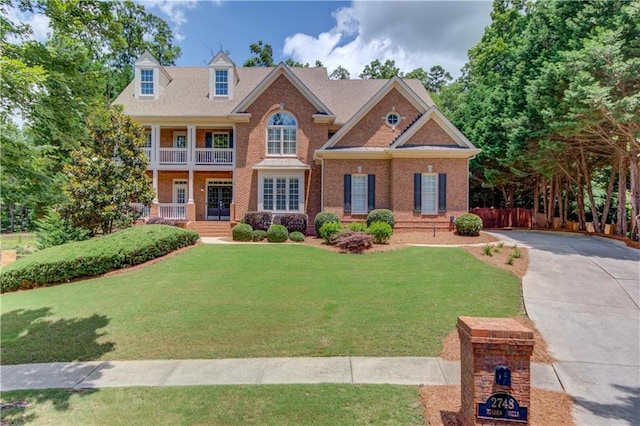 2748 Hidden Falls Dr, Buford, GA 30519 - view of front of property featuring a porch, a front lawn, brick siding, and driveway