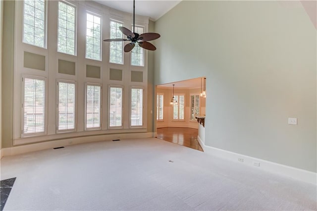 2748 Hidden Falls Dr, Buford, GA 30519 - unfurnished living room featuring carpet flooring, plenty of natural light, a towering ceiling, and a ceiling fan