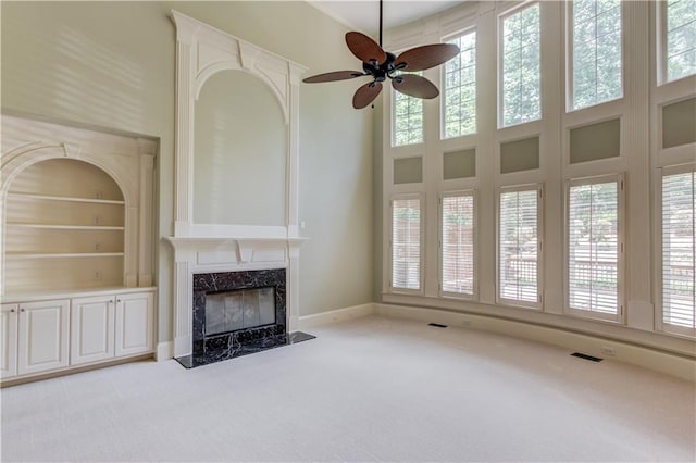 2748 Hidden Falls Dr, Buford, GA 30519 - unfurnished living room featuring carpet, a premium fireplace, ceiling fan, a towering ceiling, and built in features