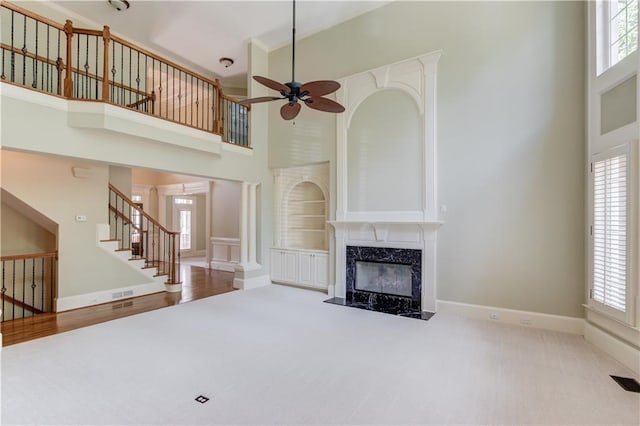 2748 Hidden Falls Dr, Buford, GA 30519 - unfurnished living room featuring a high ceiling, a ceiling fan, carpet, healthy amount of natural light, and a fireplace