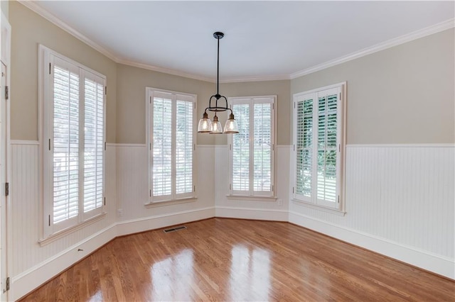 2748 Hidden Falls Dr, Buford, GA 30519 - unfurnished dining area featuring a wainscoted wall, wood finished floors, a chandelier, plenty of natural light, and ornamental molding