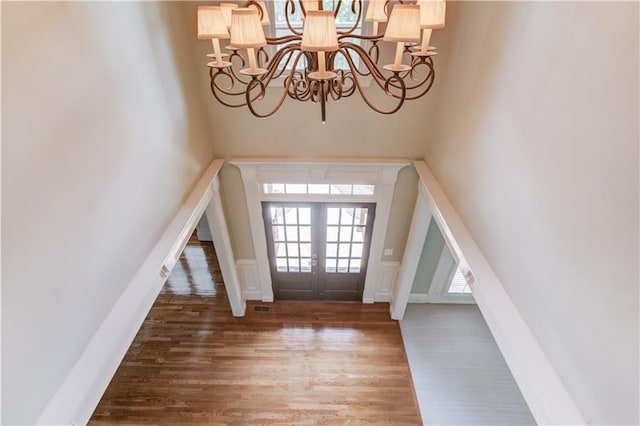 2748 Hidden Falls Dr, Buford, GA 30519 - foyer entrance featuring a chandelier, wood finished floors, a towering ceiling, french doors, and a wainscoted wall