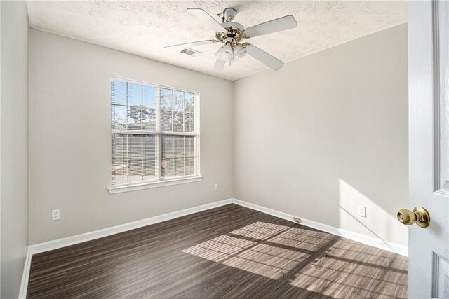 empty room featuring a textured ceiling, ceiling fan, and dark wood-type flooring