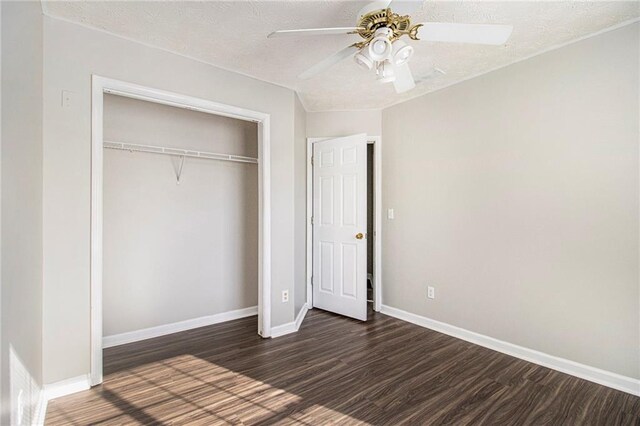 unfurnished bedroom with ceiling fan, dark hardwood / wood-style floors, a textured ceiling, and a closet