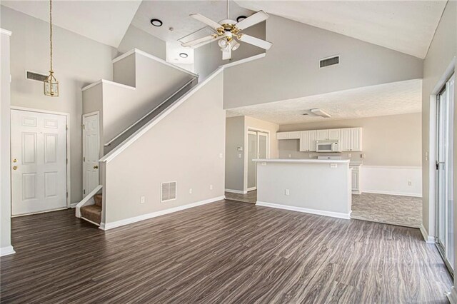 unfurnished living room with ceiling fan, high vaulted ceiling, and dark hardwood / wood-style floors