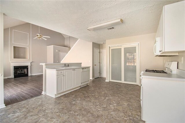 kitchen with ceiling fan, washer / clothes dryer, a textured ceiling, white appliances, and white cabinets