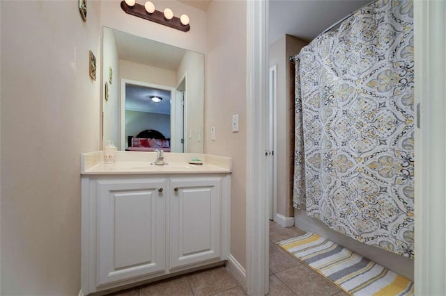full bathroom with tile patterned flooring, baseboards, vanity, and ensuite bath