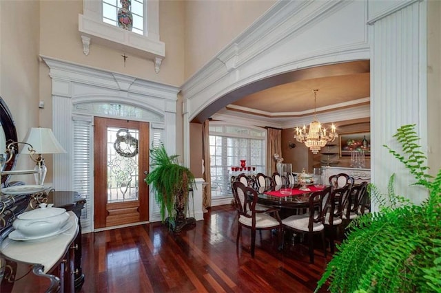 entryway with an inviting chandelier, a healthy amount of sunlight, hardwood / wood-style floors, and arched walkways