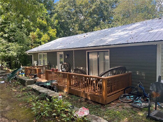 rear view of property featuring a wooden deck