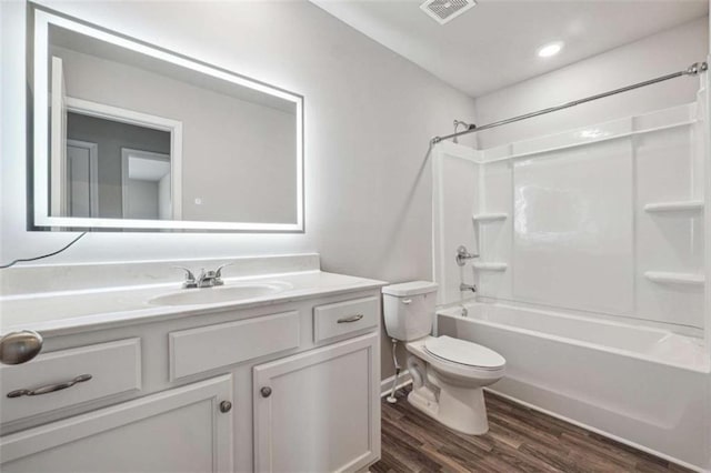 full bathroom featuring visible vents, toilet, wood finished floors, tub / shower combination, and vanity