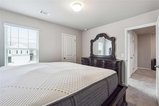 carpeted bedroom featuring multiple windows, visible vents, and baseboards