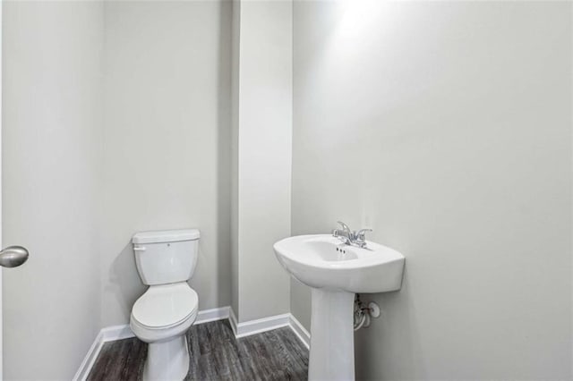 bathroom featuring toilet, baseboards, and wood finished floors