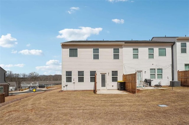 back of property with a lawn, a patio area, and fence