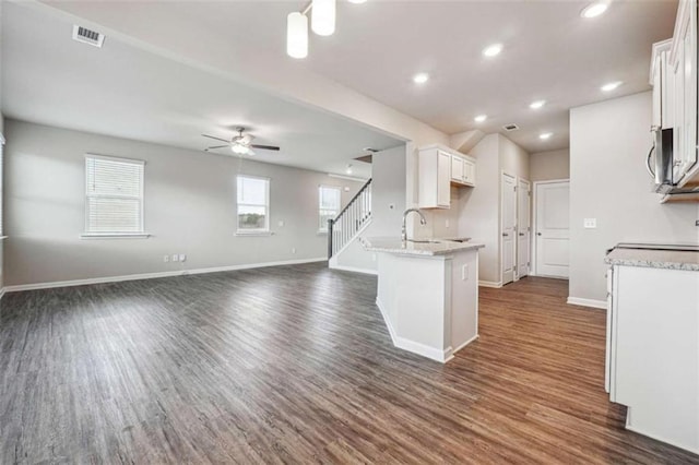 kitchen featuring ceiling fan, visible vents, white cabinetry, baseboards, and dark wood finished floors