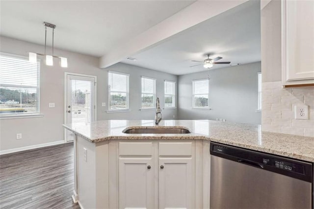 kitchen featuring light stone counters, white cabinets, dishwasher, and a sink