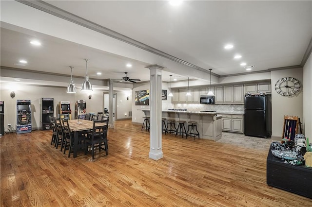 dining room featuring decorative columns, a ceiling fan, crown molding, light wood-style floors, and recessed lighting