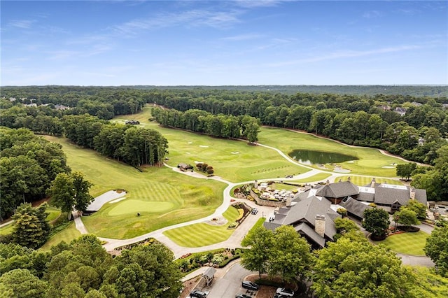 drone / aerial view featuring golf course view and a view of trees