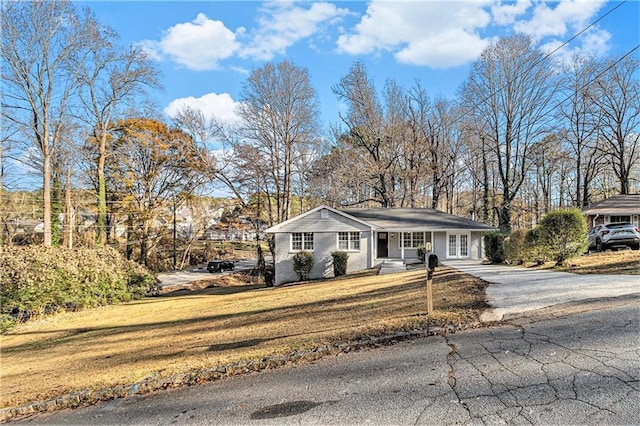 single story home with covered porch and a front yard