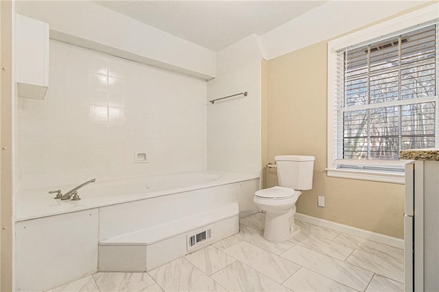 bathroom featuring a tub and toilet