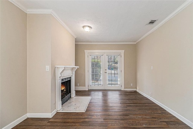 unfurnished living room with dark hardwood / wood-style flooring, french doors, a textured ceiling, and ornamental molding