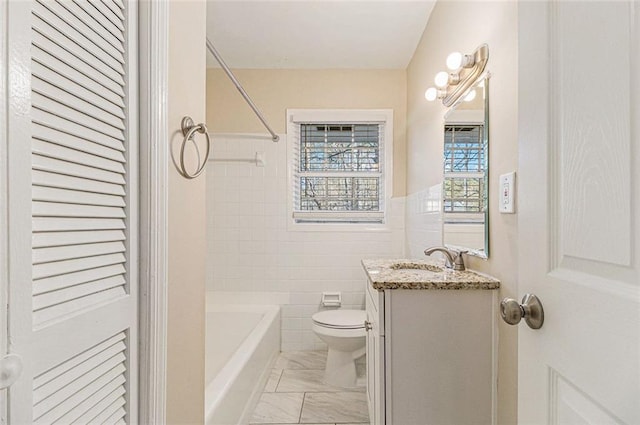 full bathroom with vanity, shower / bath combination, toilet, and tile walls