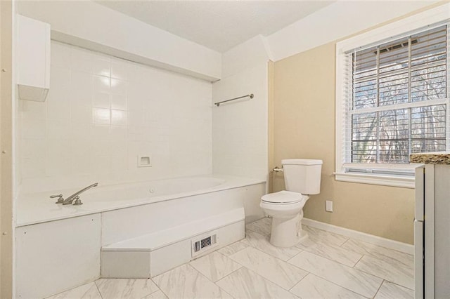 bathroom with a washtub and toilet