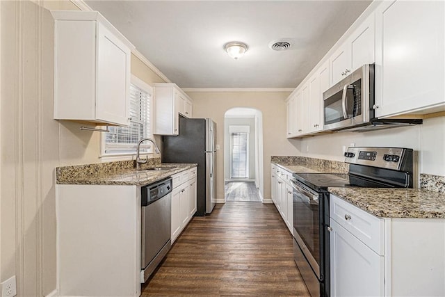 kitchen featuring white cabinets, appliances with stainless steel finishes, crown molding, and sink