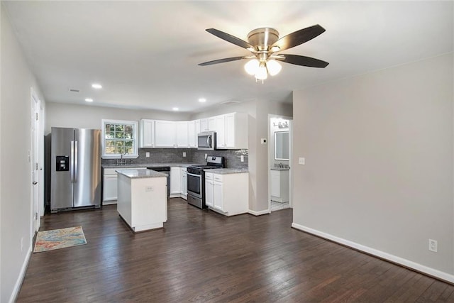 kitchen featuring stainless steel appliances, dark wood-type flooring, a kitchen island, and decorative backsplash