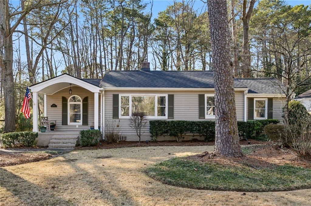 ranch-style house with a porch and a front yard