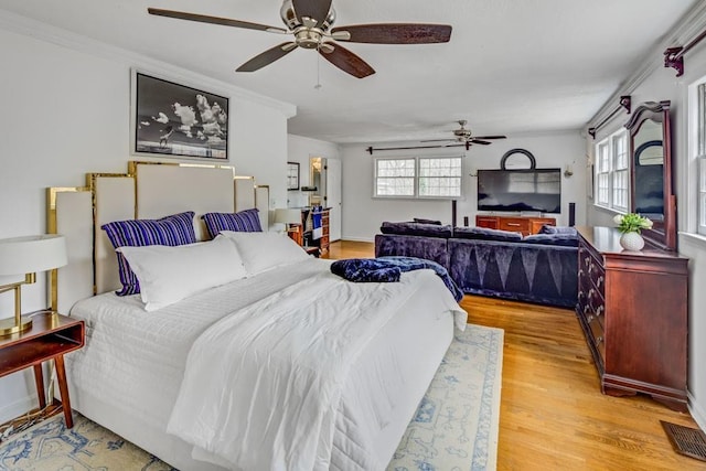 bedroom featuring crown molding, light hardwood / wood-style floors, and ceiling fan