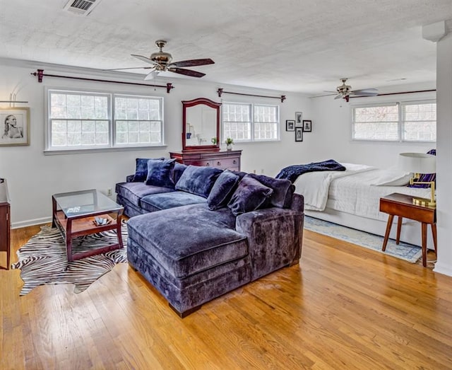 living room featuring hardwood / wood-style floors, a textured ceiling, and ceiling fan