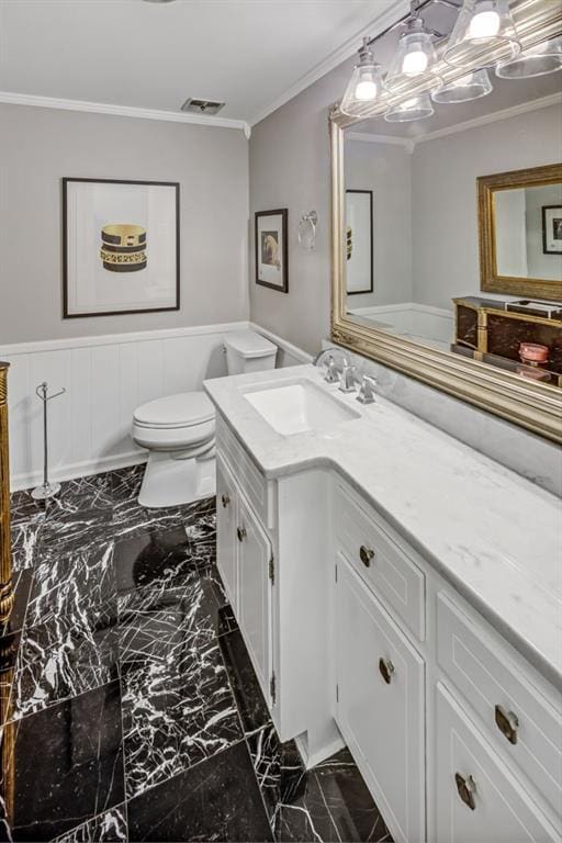 bathroom with vanity, crown molding, and toilet