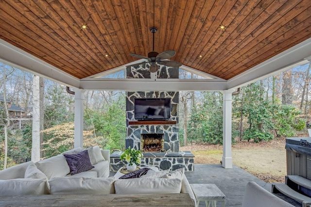 exterior space featuring a gazebo, ceiling fan, an outdoor living space with a fireplace, and a patio