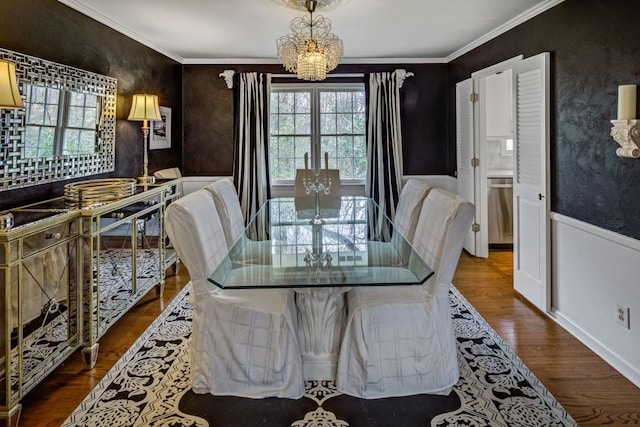 dining area with hardwood / wood-style floors, a notable chandelier, and ornamental molding