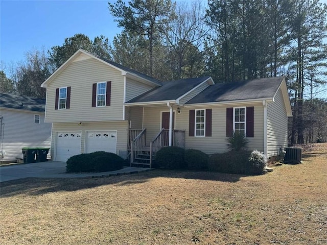 split level home with a garage, a front lawn, and central air condition unit