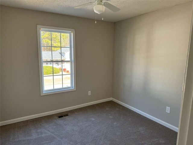 carpeted spare room featuring ceiling fan, plenty of natural light, and a textured ceiling