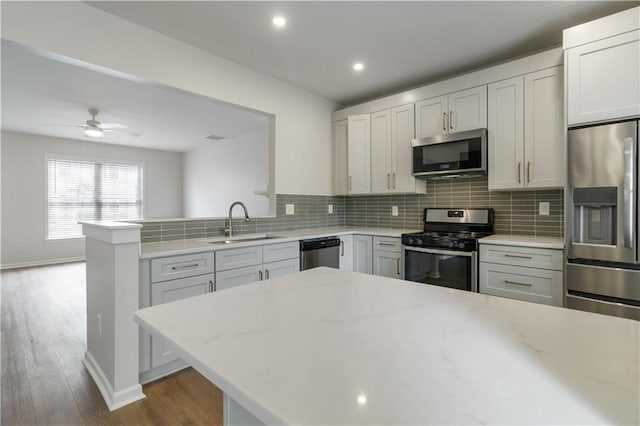 13300 Morris Rd Unit 76, Alpharetta, GA 30004 - unfurnished living room with a warm lit fireplace, ceiling fan with notable chandelier, stairs, baseboards, and wood finished floors