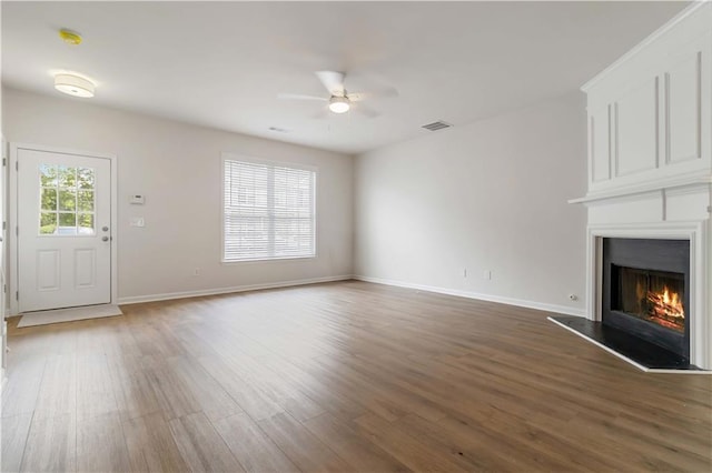 13300 Morris Rd Unit 76, Alpharetta, GA 30004 - unfurnished living room featuring a fireplace, ceiling fan with notable chandelier, recessed lighting, baseboards, and wood finished floors