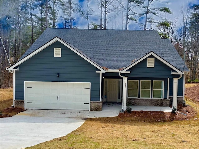 view of front facade featuring an attached garage, brick siding, driveway, and roof with shingles