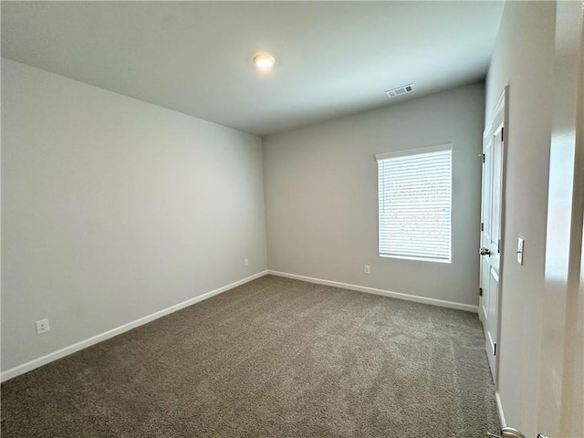 carpeted spare room featuring visible vents and baseboards