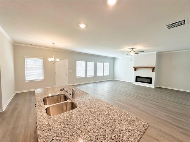 kitchen featuring a sink, visible vents, crown molding, and ceiling fan with notable chandelier