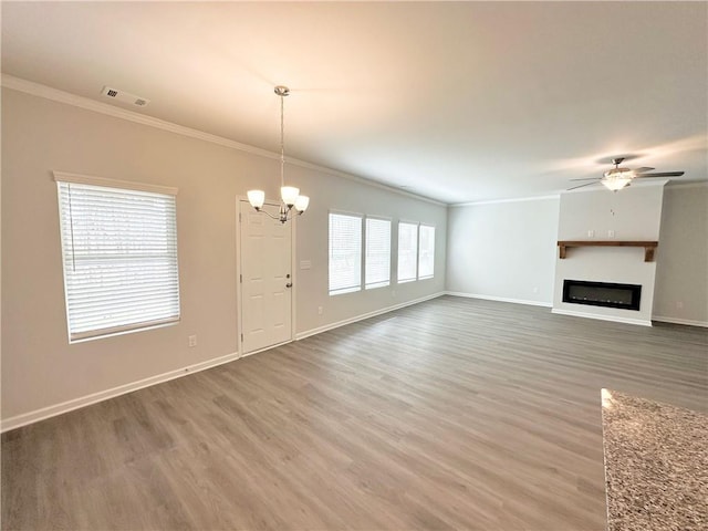 unfurnished living room with visible vents, ceiling fan with notable chandelier, crown molding, and wood finished floors