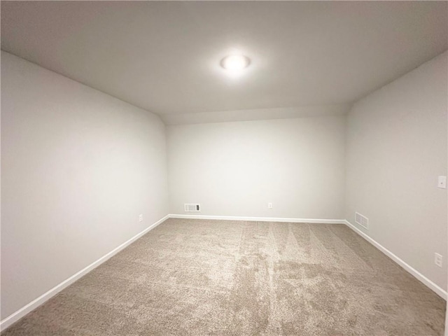 carpeted empty room with visible vents and baseboards